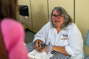 Dr Debra Dank signs copies of her latest book, We Come With This Place. Photo by Greg Jackson. 